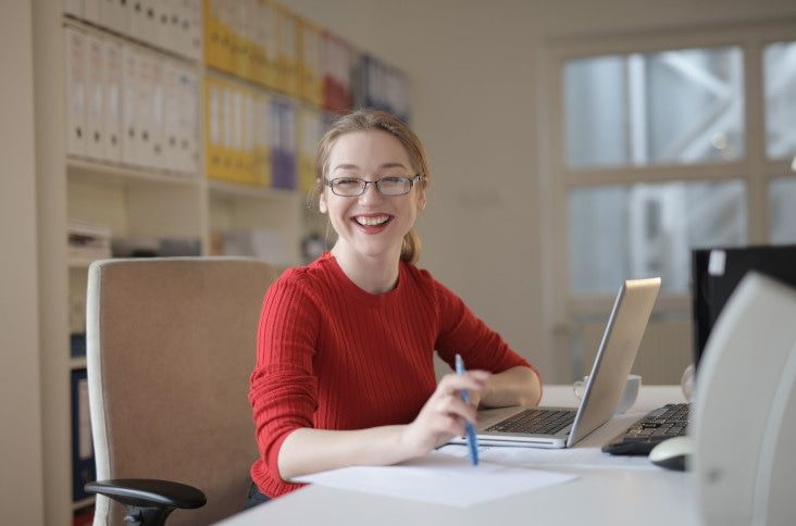 A girl smiles while using one of the best apps for university students: Mendeley.