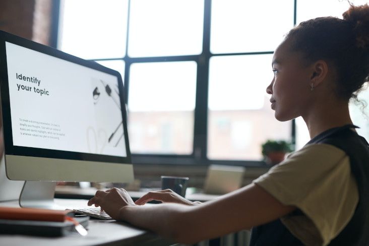 A university student sitting in front of a computer as she organises her study plan.